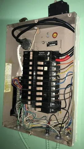 Residential electrical panel with its cover removed, showing the breakers and wiring an inspector checks