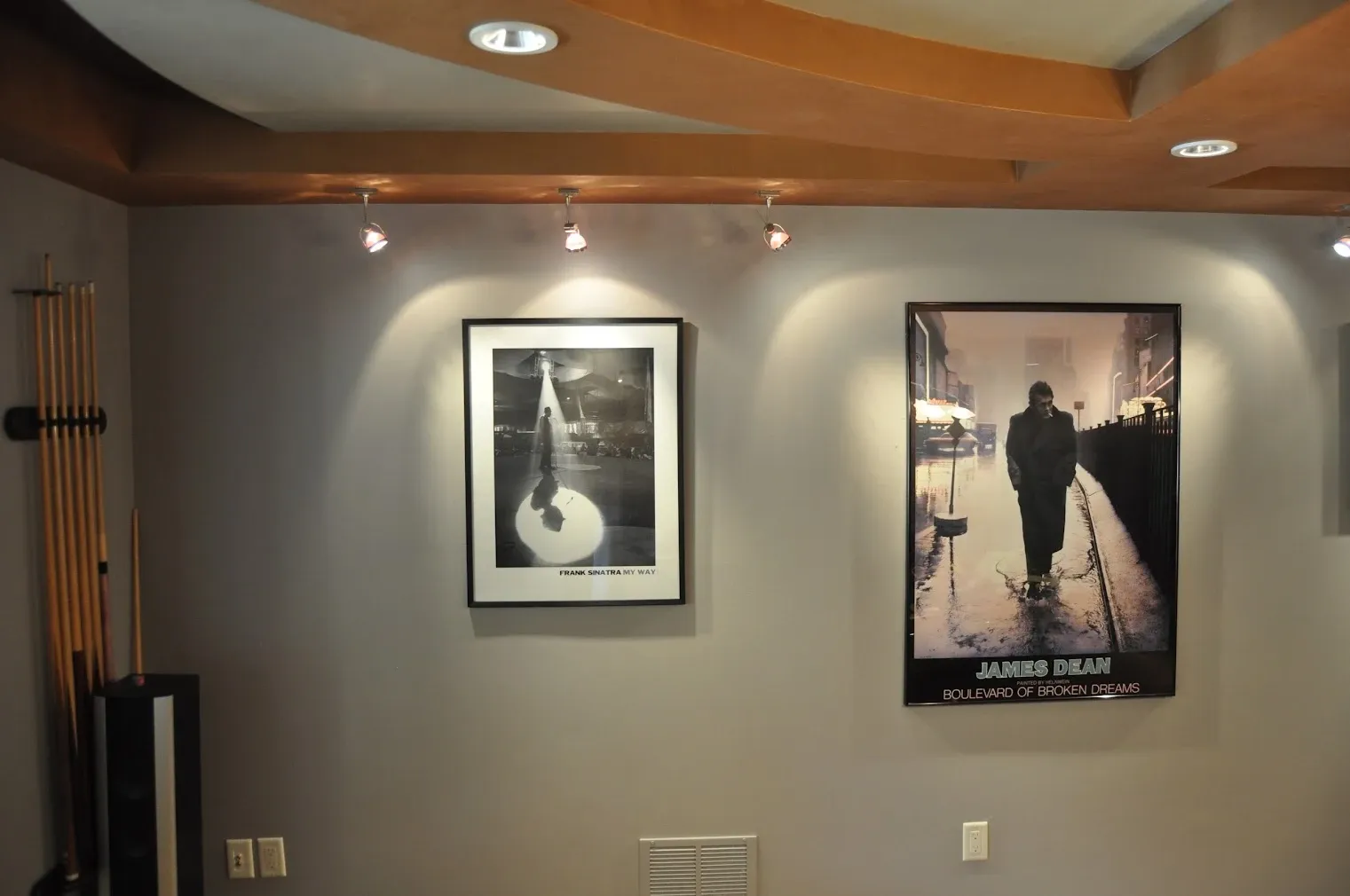 Finished room with recessed and track lighting aimed at framed artwork