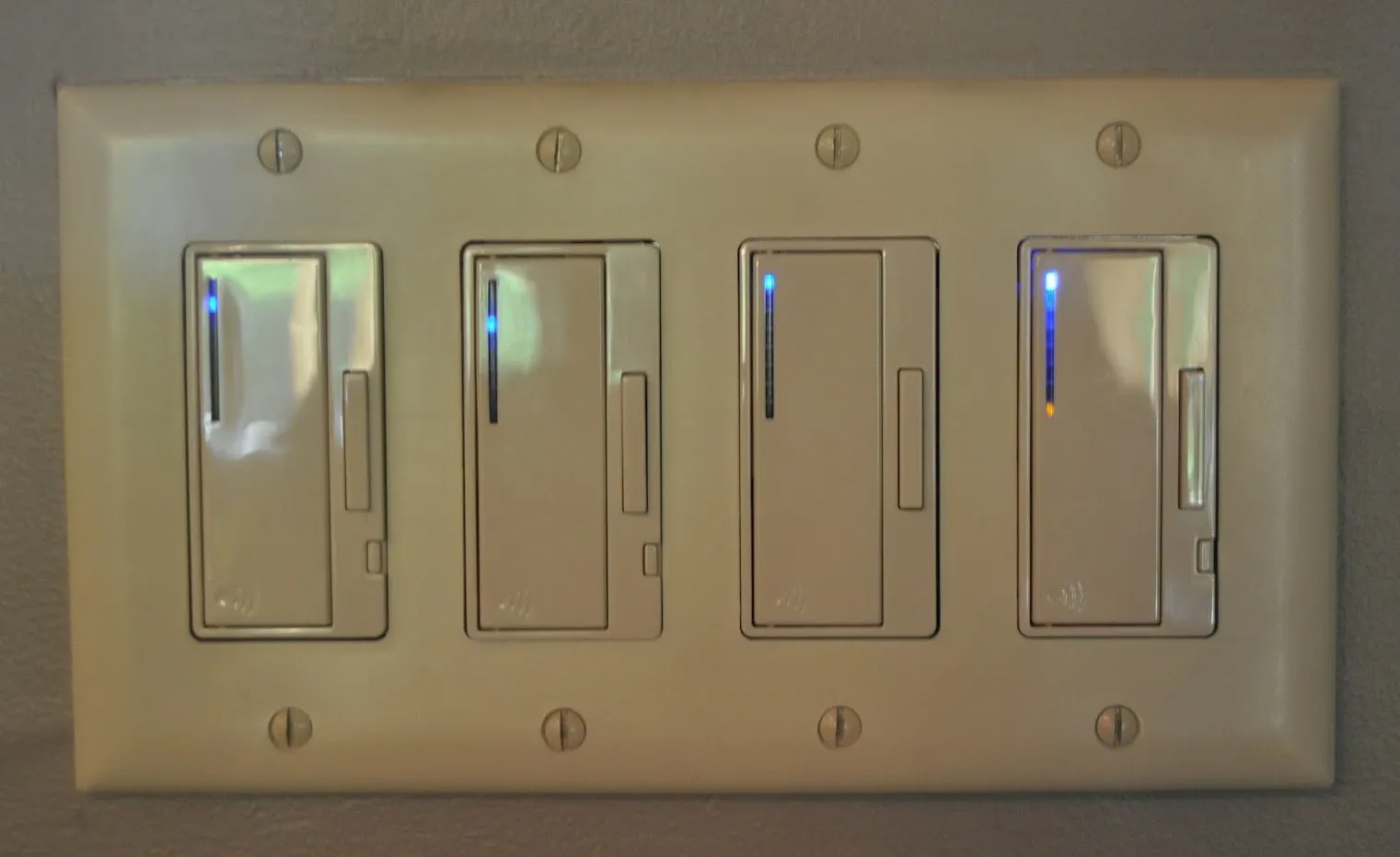 Newly installed four-gang dimmer switch plate on a wall