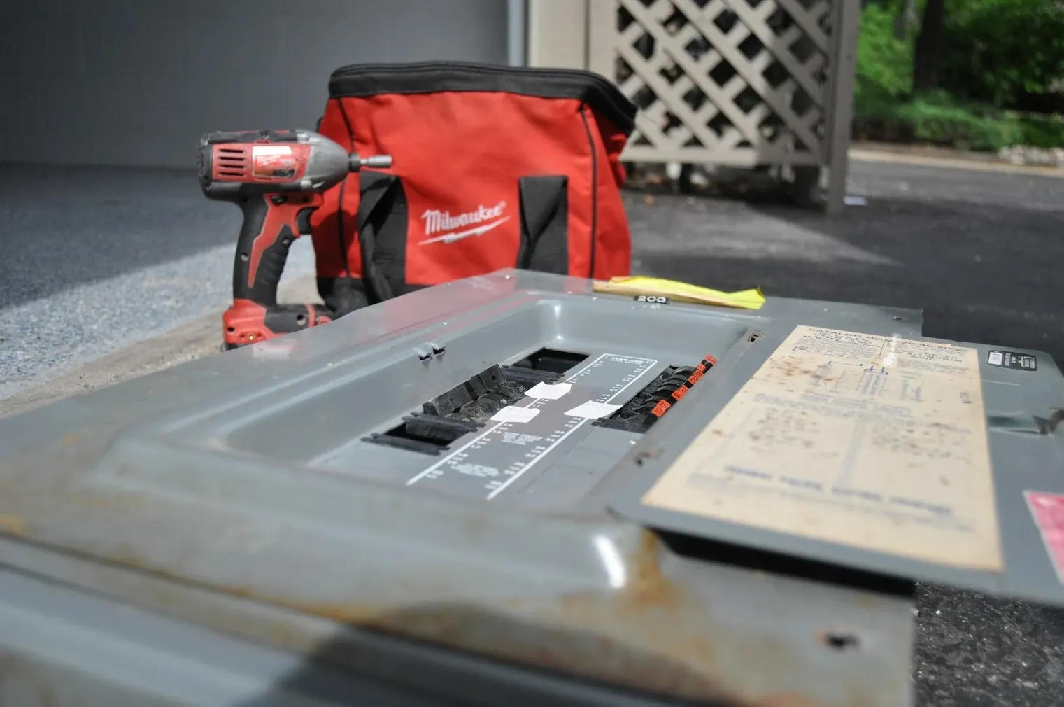 Old electrical panel removed during a panel replacement, set outside next to the electrician's tools